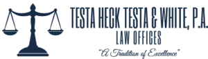 Logo of Testa, Heck, Testa & White, P.A. law offices featuring a community-based balance scale, predominantly in teal and navy colors, with the tagline "A Tradition of Excellence