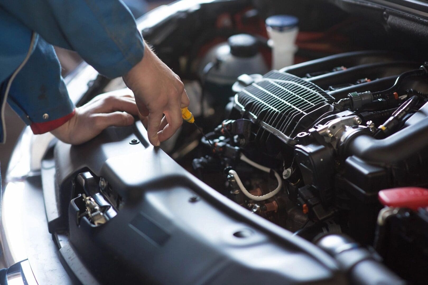 A man is working on the engine of a car.