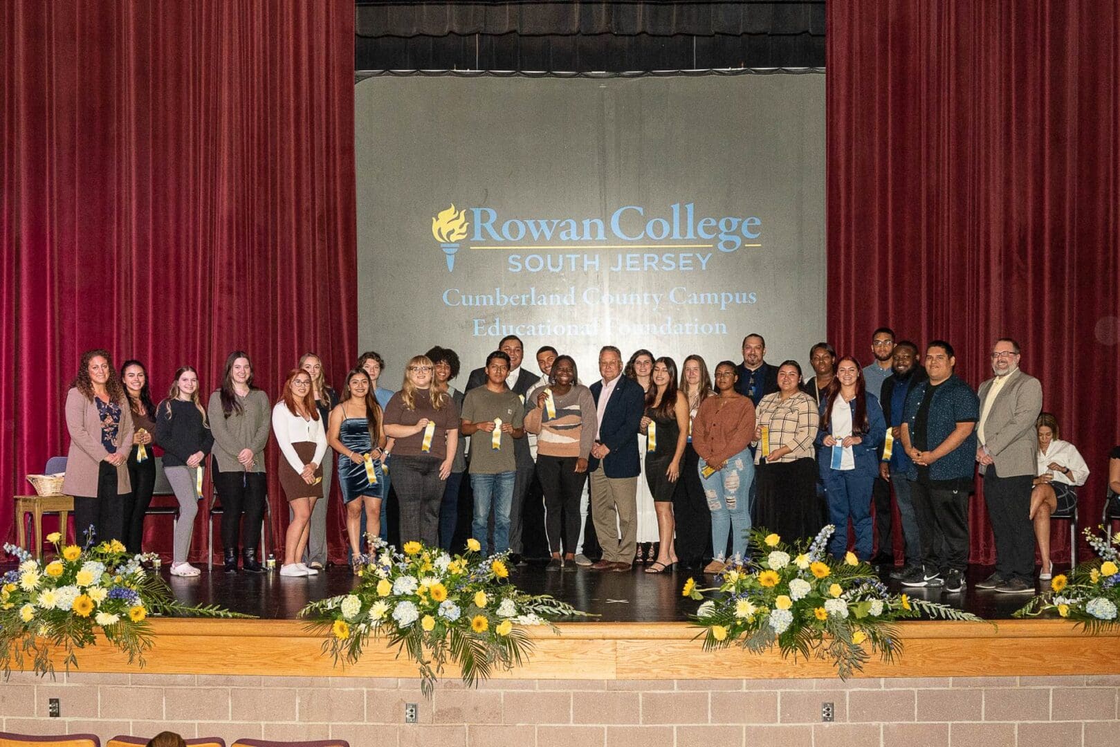 A group of people posing for a picture on stage.