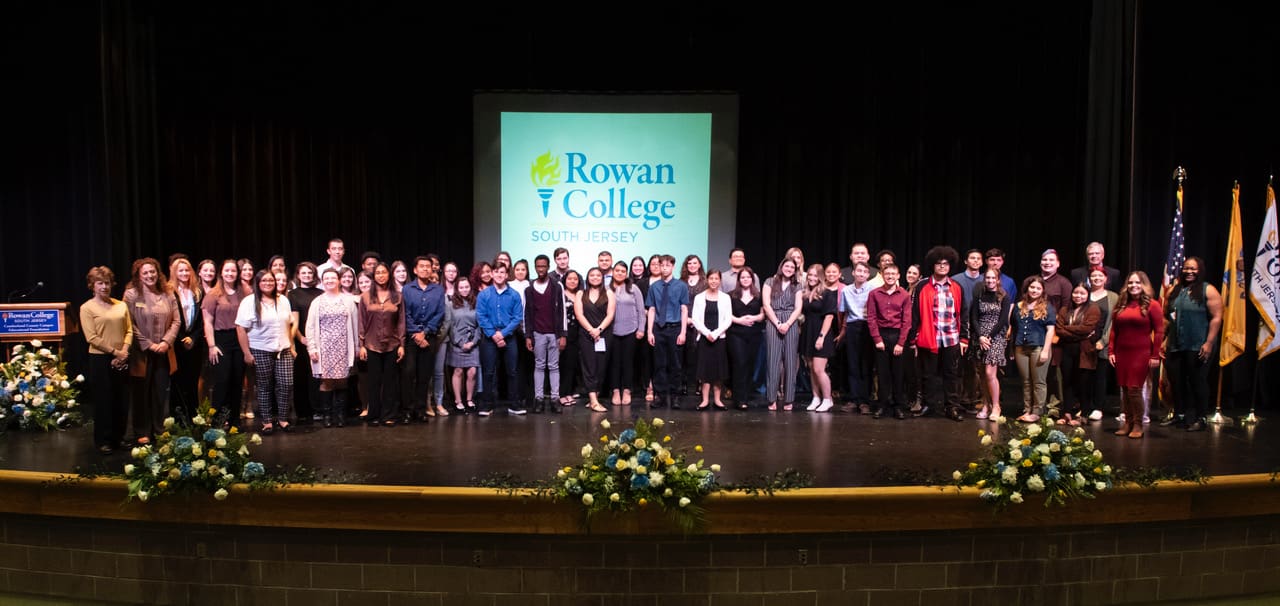 A group of people posing for a picture on stage.