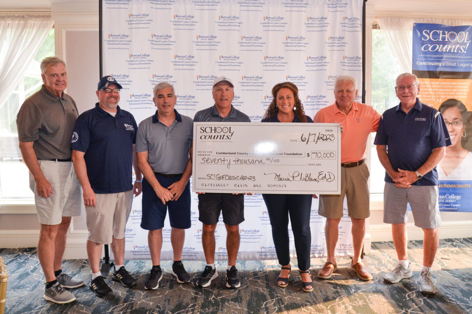 A group of people posing for a picture with a check.