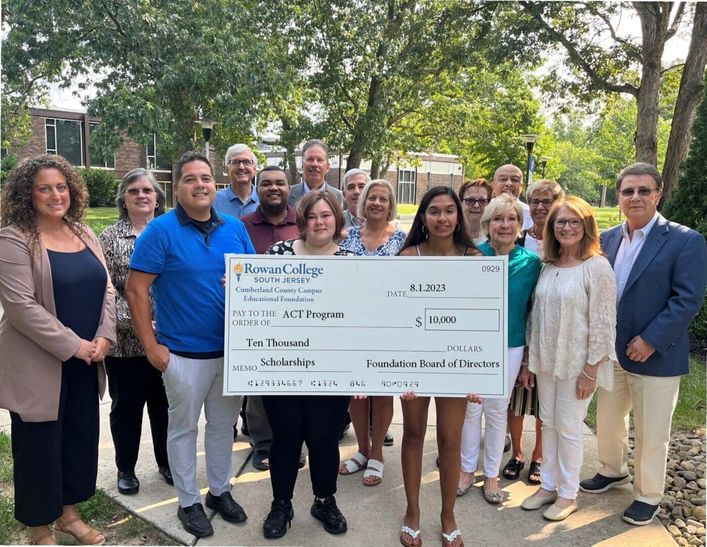 A group of people standing in front of a large check.