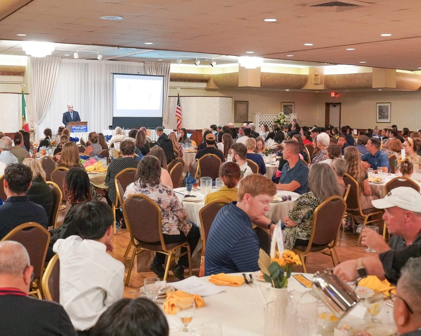 A large group of people sitting at tables in a room.