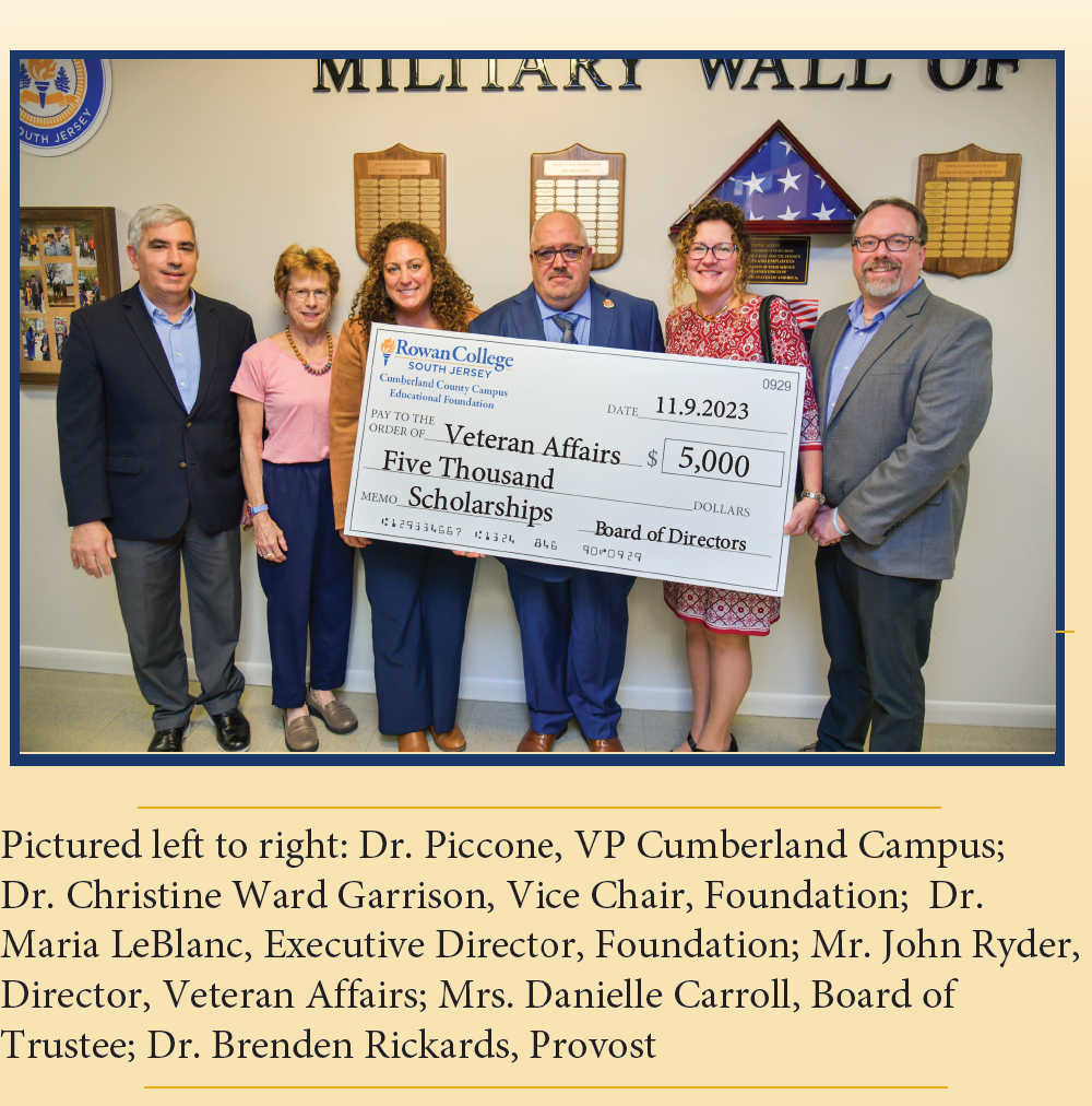 A group of people holding a check for the military wall of honor.