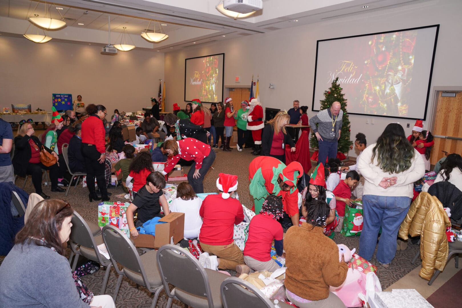 A group of people are gathered around a christmas tree.