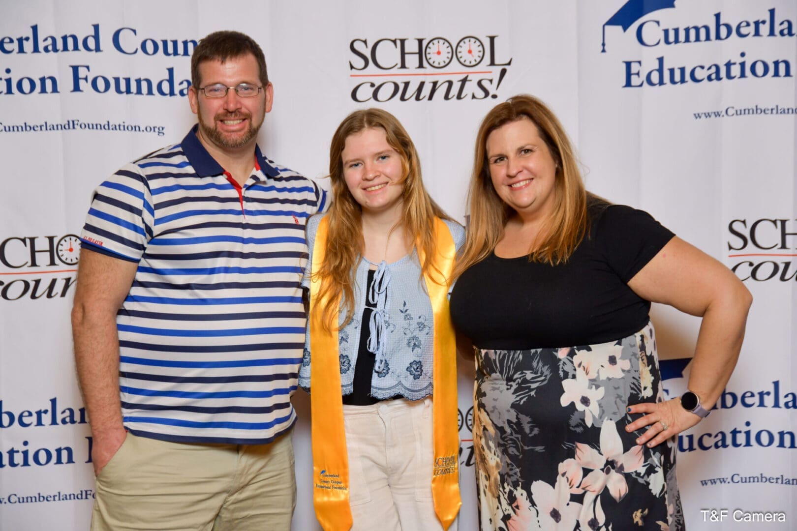 Smiling family with graduate wearing gold stole